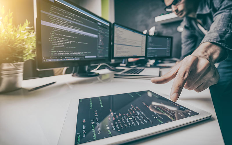 Man working with multiple screens