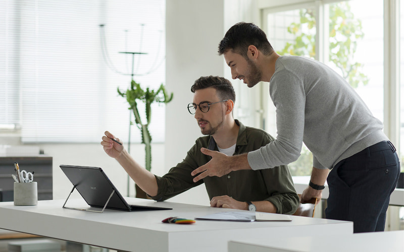 Two men working on a laptop