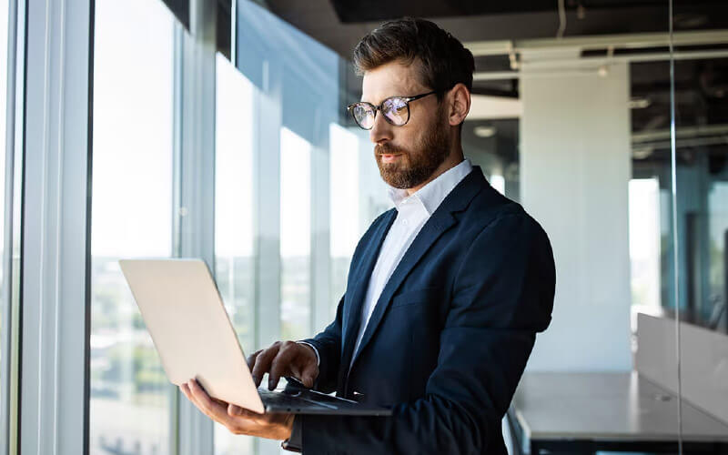 Man with glasses using his laptop