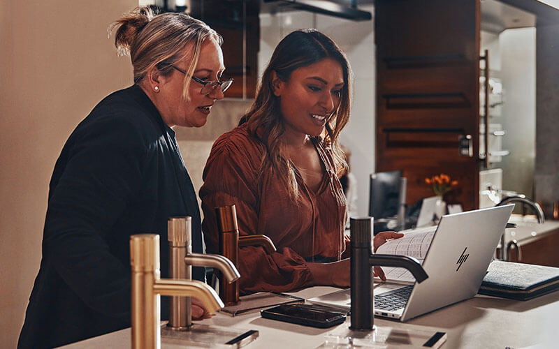 Two woman using Lenovo laptop