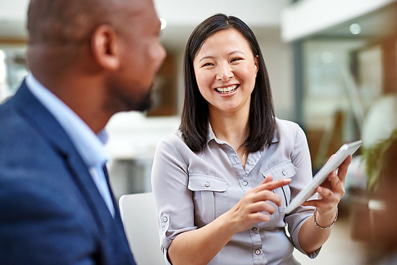 Smiling business professional on tablet computer with client